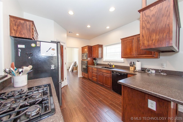 kitchen with black appliances, a sink, dark countertops, recessed lighting, and dark wood-style flooring