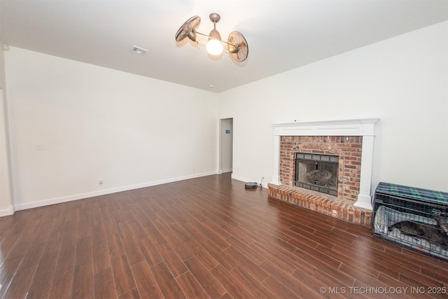 unfurnished living room featuring wood finished floors, a fireplace, and baseboards