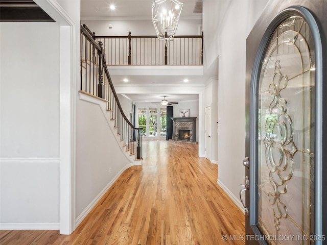 506 E 120th Pl S, Jenks, OK 74037 - foyer entrance with light wood-style flooring, stairs, ornamental molding, a fireplace, and baseboards