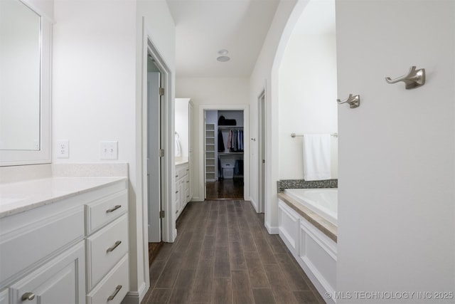 16958 E 45th St, Tulsa, OK 74134 - full bath featuring vanity, a bath, a walk in closet, and wood finished floors