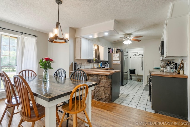 30341 E 144th St, Coweta, OK 74429 - dining space featuring ceiling fan, a textured ceiling, a chandelier, and light wood finished floors