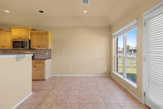 2000 W Vail St, Broken Arrow, OK 74012 - kitchen featuring stainless steel microwave, healthy amount of natural light, dark countertops, backsplash, and recessed lighting