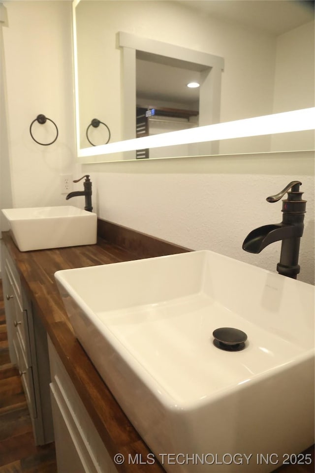 1185 E Pine St, Westville, OK 74965 - bathroom featuring wood finished floors and double vanity