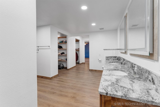 5378 W 450th Rd, Pryor, OK 74361 - kitchen featuring a sink, baseboards, light stone counters, recessed lighting, and light wood-style floors