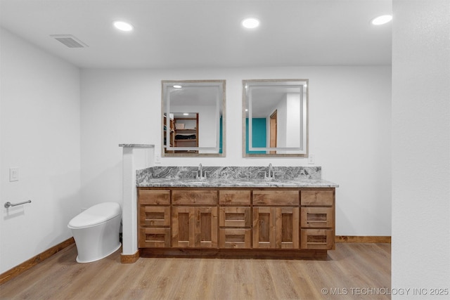 5378 W 450th Rd, Pryor, OK 74361 - full bathroom featuring wood finished floors, baseboards, double vanity, toilet, and recessed lighting