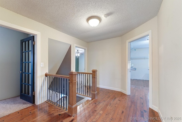 5378 W 450th Rd, Pryor, OK 74361 - hall with an upstairs landing, wood finished floors, a textured ceiling, and baseboards