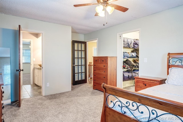 5378 W 450th Rd, Pryor, OK 74361 - bedroom featuring light colored carpet, a spacious closet, connected bathroom, a closet, and a textured ceiling