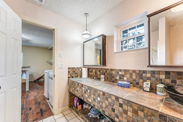 5378 W 450th Rd, Pryor, OK 74361 - bathroom with washer and clothes dryer, a textured ceiling, tasteful backsplash, and tile patterned floors