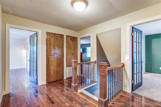 5378 W 450th Rd, Pryor, OK 74361 - hallway with an upstairs landing, wood finished floors, a textured ceiling, baseboards, and french doors