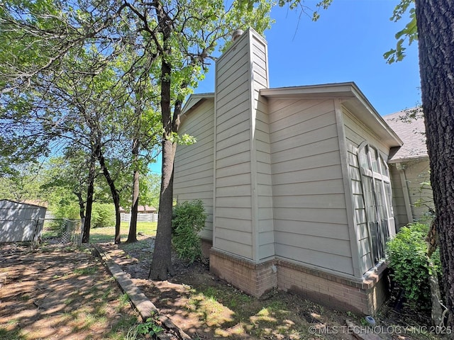 7333 W 36th St, Tulsa, OK 74107 - view of side of property with a chimney and fence