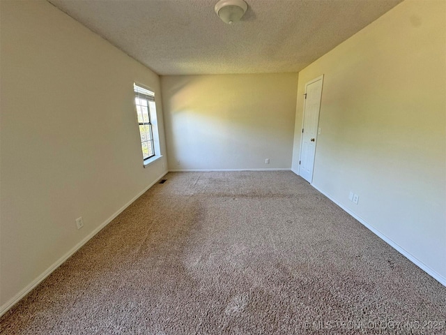 7333 W 36th St, Tulsa, OK 74107 - empty room featuring a textured ceiling, carpet flooring, and baseboards