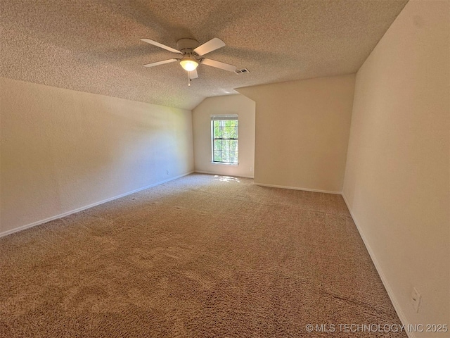 7333 W 36th St, Tulsa, OK 74107 - carpeted empty room featuring a ceiling fan, vaulted ceiling, a textured ceiling, and baseboards