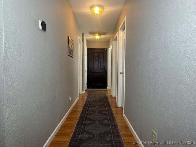2836 E Admiral Blvd, Tulsa, OK 74110 - hallway featuring a textured wall, baseboards, and wood finished floors