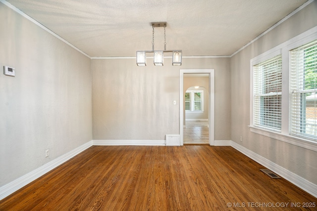 1648 S Columbia Pl, Tulsa, OK 74104 - unfurnished dining area featuring crown molding, baseboards, wood finished floors, plenty of natural light, and a textured ceiling