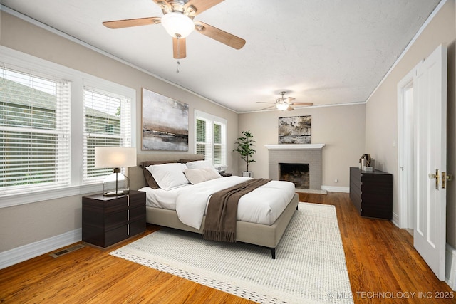 1648 S Columbia Pl, Tulsa, OK 74104 - bedroom featuring ornamental molding, wood finished floors, baseboards, a fireplace, and ceiling fan