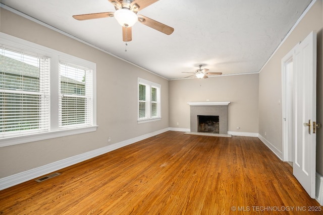1648 S Columbia Pl, Tulsa, OK 74104 - unfurnished living room with ceiling fan, wood finished floors, baseboards, a brick fireplace, and crown molding