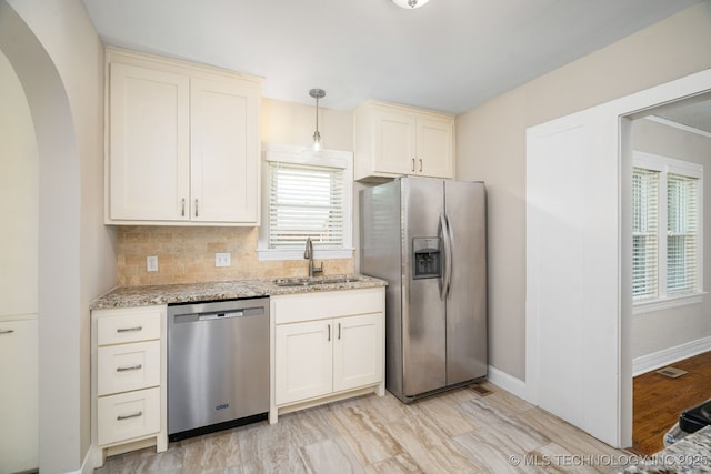 1648 S Columbia Pl, Tulsa, OK 74104 - kitchen featuring appliances with stainless steel finishes, a sink, light stone counters, backsplash, and arched walkways