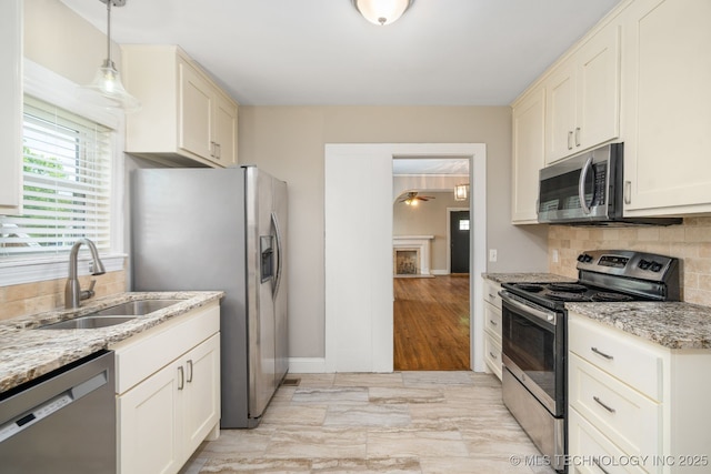 1648 S Columbia Pl, Tulsa, OK 74104 - kitchen featuring appliances with stainless steel finishes, a sink, decorative backsplash, and light stone countertops