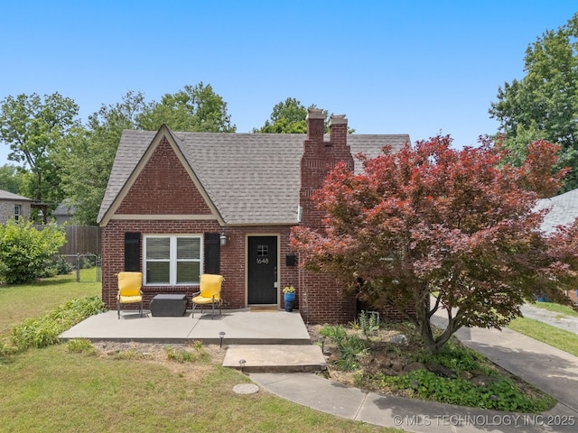 1648 S Columbia Pl, Tulsa, OK 74104 - tudor-style house with a chimney, roof with shingles, and brick siding