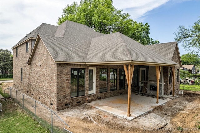 view of front of house featuring crawl space, brick siding, a patio, and a shingled roof