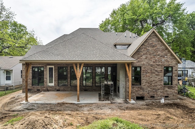 rear view of house featuring crawl space, a patio area, and brick siding