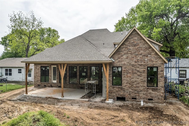 back of property featuring crawl space, a patio area, roof with shingles, brick siding, and fence