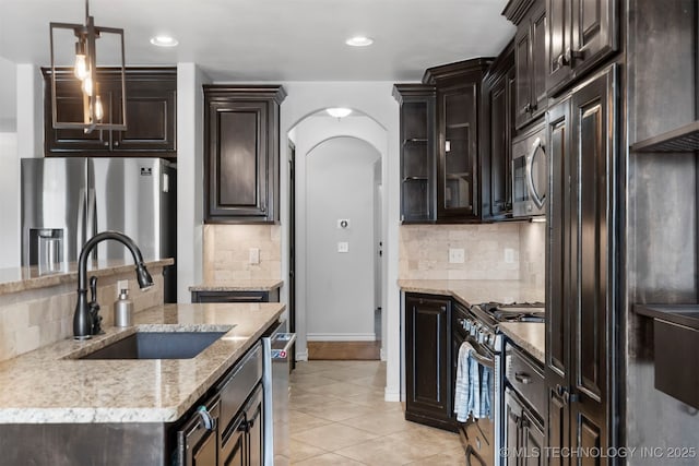 kitchen featuring appliances with stainless steel finishes, a sink, decorative backsplash, and recessed lighting