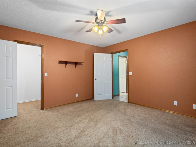 1310 Prairie Heights Dr, Bartlesville, OK 74006 - unfurnished bedroom with carpet floors, baseboards, a ceiling fan, and a spacious closet