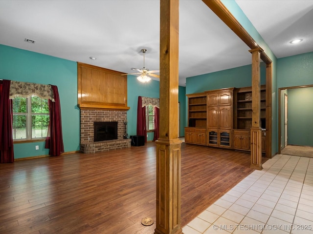 1310 Prairie Heights Dr, Bartlesville, OK 74006 - unfurnished living room featuring ornate columns, light wood-type flooring, a fireplace, a ceiling fan, and recessed lighting