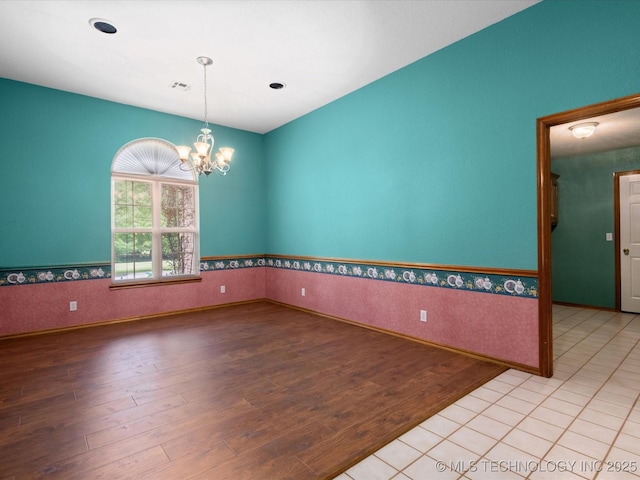 1310 Prairie Heights Dr, Bartlesville, OK 74006 - spare room featuring wood finished floors, a chandelier, and baseboards