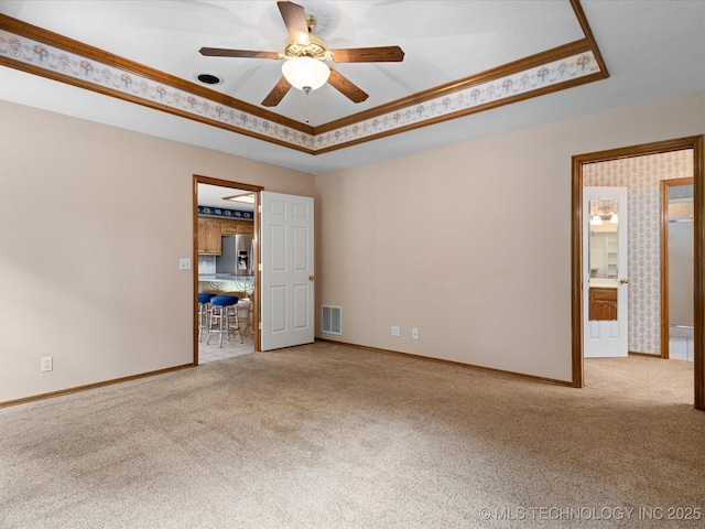 1310 Prairie Heights Dr, Bartlesville, OK 74006 - carpeted spare room featuring a raised ceiling, ornamental molding, ceiling fan, and baseboards