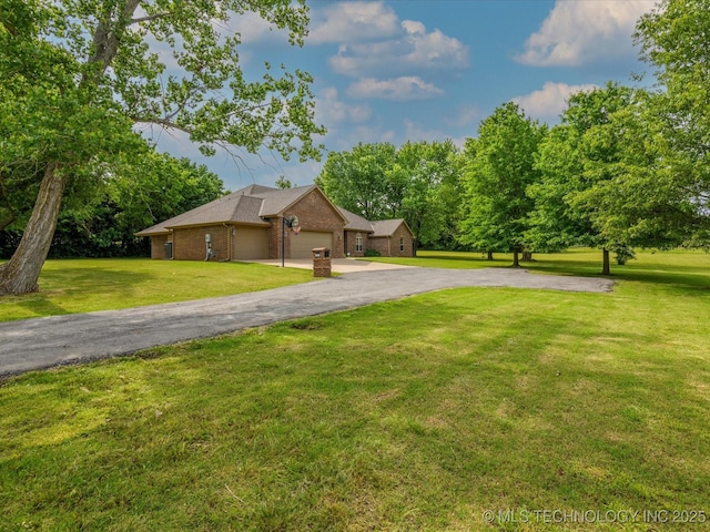 1310 Prairie Heights Dr, Bartlesville, OK 74006 - view of side of property with a lawn, asphalt driveway, brick siding, and an attached garage