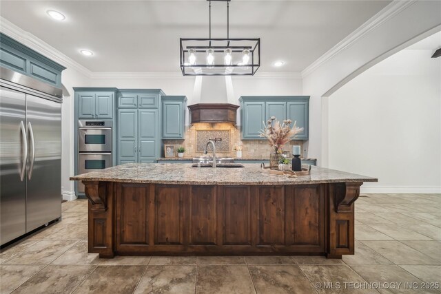 11408 S Harvard Ave, Tulsa, OK 74137 - kitchen with stainless steel appliances, blue cabinetry, premium range hood, decorative backsplash, and ornamental molding