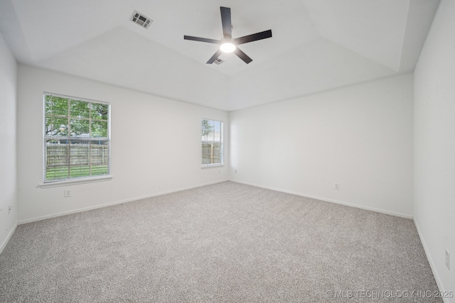 unfurnished room featuring carpet, ceiling fan, a tray ceiling, and baseboards
