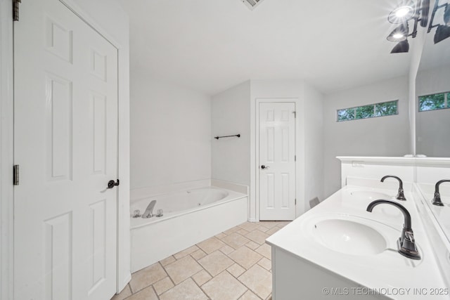 bathroom with a bath, double vanity, and stone finish flooring