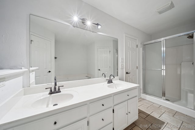 bathroom featuring a shower stall, double vanity, and a garden tub