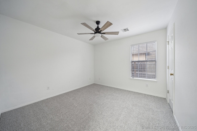 spare room with a ceiling fan, carpet, and baseboards
