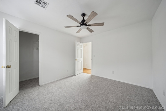 unfurnished bedroom featuring carpet, baseboards, and a spacious closet