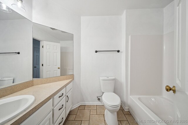 bathroom with toilet, vanity, and baseboards