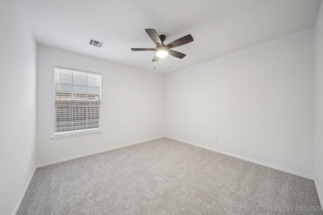 carpeted empty room featuring baseboards and a ceiling fan
