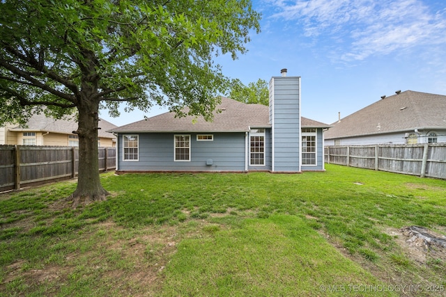rear view of property with a chimney and roof with shingles