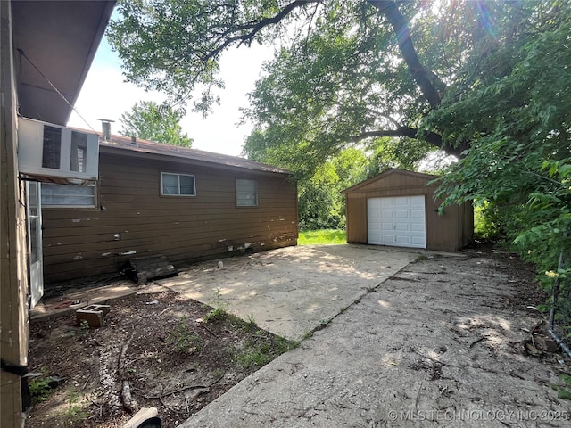 628 S 105th E Pl, Tulsa, OK 74128 - view of patio / terrace with a garage, an outbuilding, and driveway