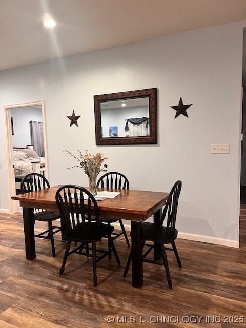 dining area featuring dark wood-type flooring and baseboards
