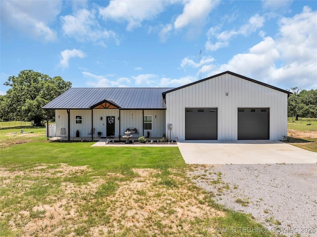 modern inspired farmhouse with board and batten siding, driveway, a front lawn, metal roof, and an attached garage