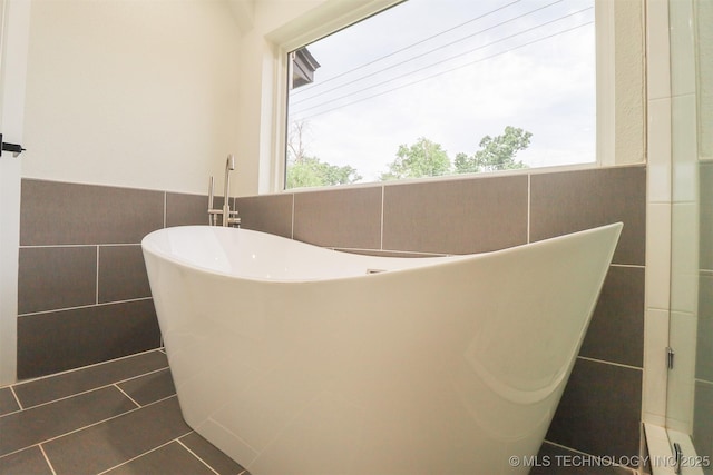 2503 S Birmingham Ave, Tulsa, OK 74114 - bathroom view of tile walls, a freestanding tub, a wainscoted wall, and a baseboard radiator
