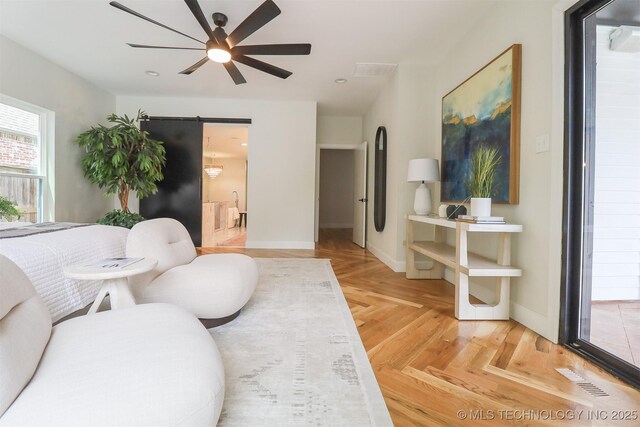 2503 S Birmingham Ave, Tulsa, OK 74114 - living room with a barn door, ceiling fan, and baseboards