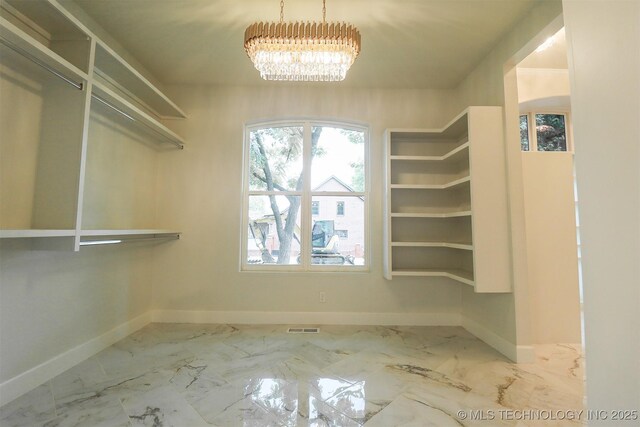 2503 S Birmingham Ave, Tulsa, OK 74114 - walk in closet featuring a chandelier and marble finish flooring