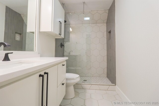 2503 S Birmingham Ave, Tulsa, OK 74114 - bathroom with toilet, vanity, tile patterned floors, a tile shower, and baseboards