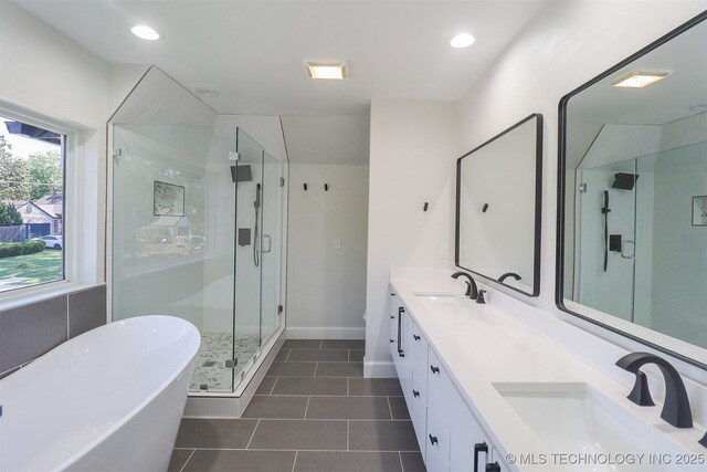 2503 S Birmingham Ave, Tulsa, OK 74114 - bathroom featuring double vanity, a stall shower, tile patterned floors, a soaking tub, and baseboards