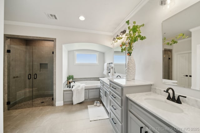 bathroom with a stall shower, a garden tub, ornamental molding, two vanities, and tile patterned floors